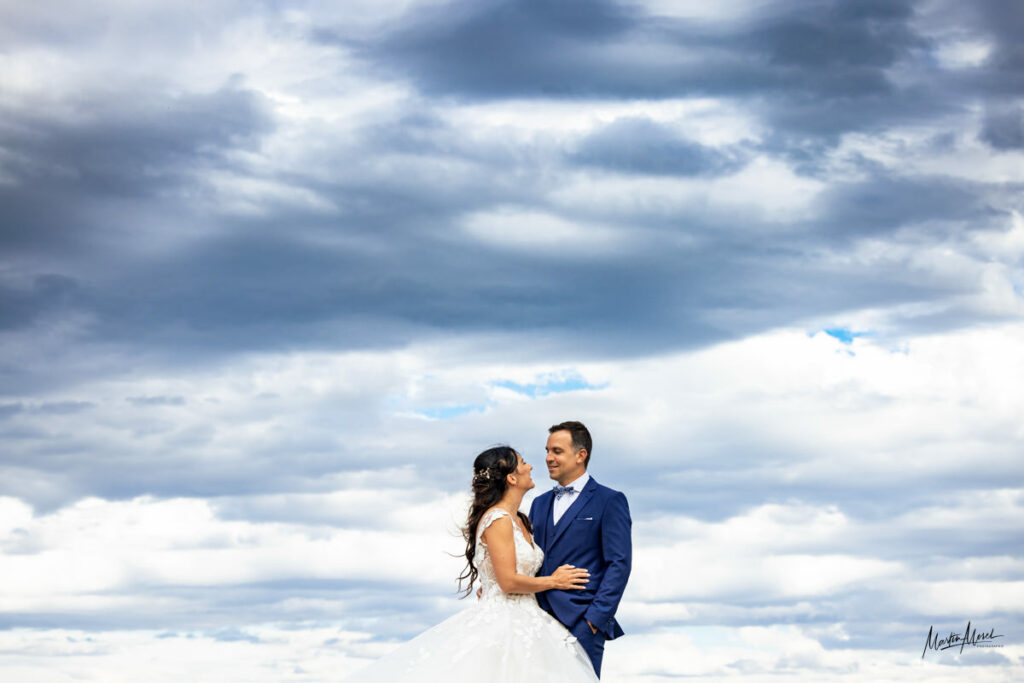 Ce couple de mariés isolé dans un magnifique ciel nuageux