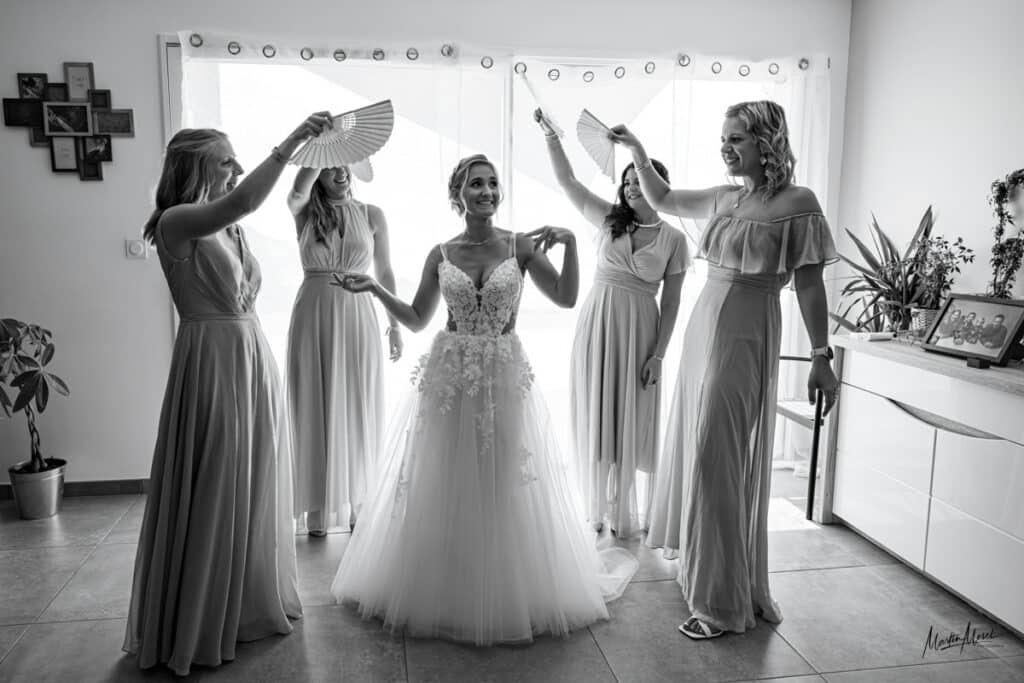 La mariée est chouchoutée entourée de ses amies qui agitent des éventails autour d'elle