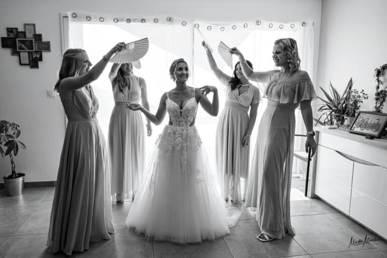 La mariée est chouchoutée entourée de ses amies qui agitent des éventails autour d'elle