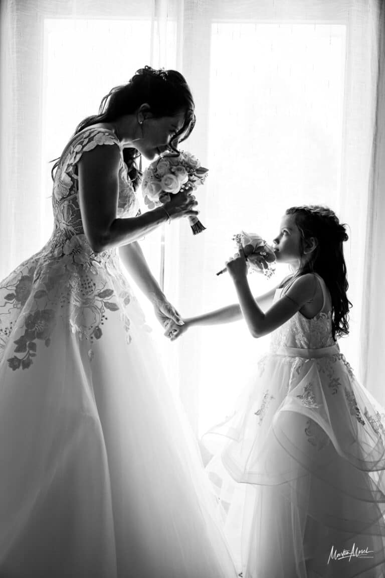 Un moment de complicité où la mariée remet un bouquet à sa fille, chacune sentira le parfum délicieux des fleurs