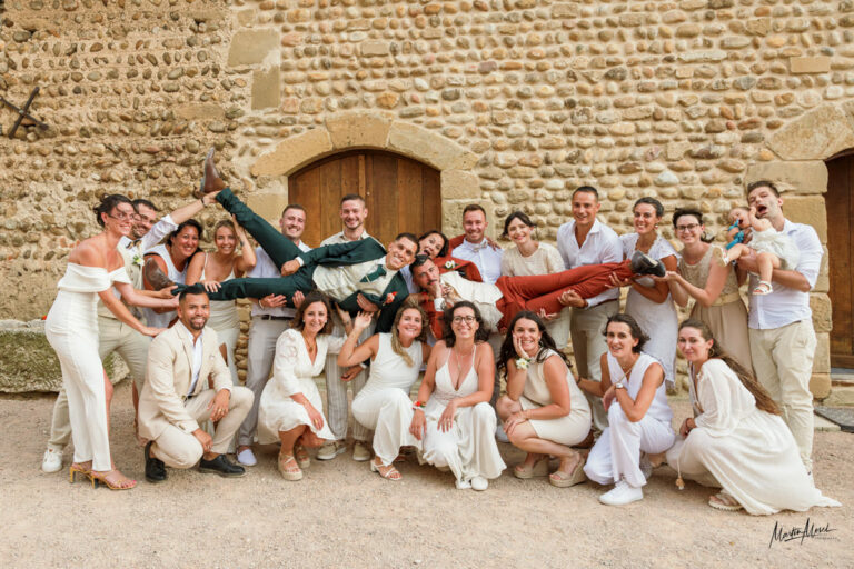 Les mariés portés par leurs amis pour une photo de groupe originale